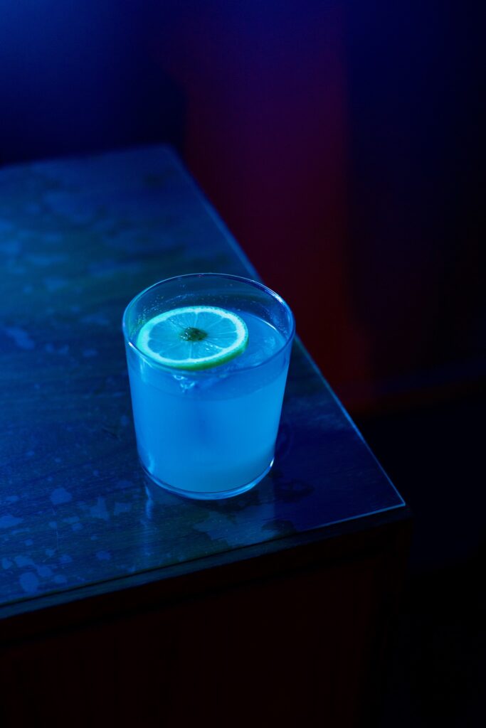 IMG_0922 A lemon drop cocktail sits on a table, illuminated by blue light at the Play It Cool pop-up bar.